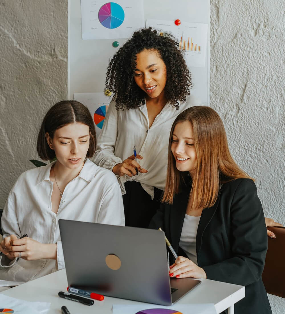 a few women looking at a laptop