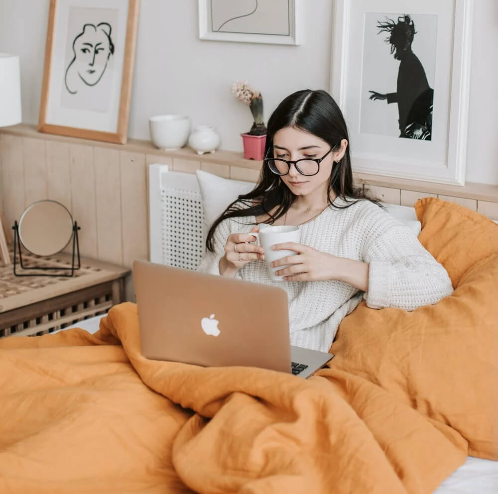 a woman sitting on a couch with a laptop