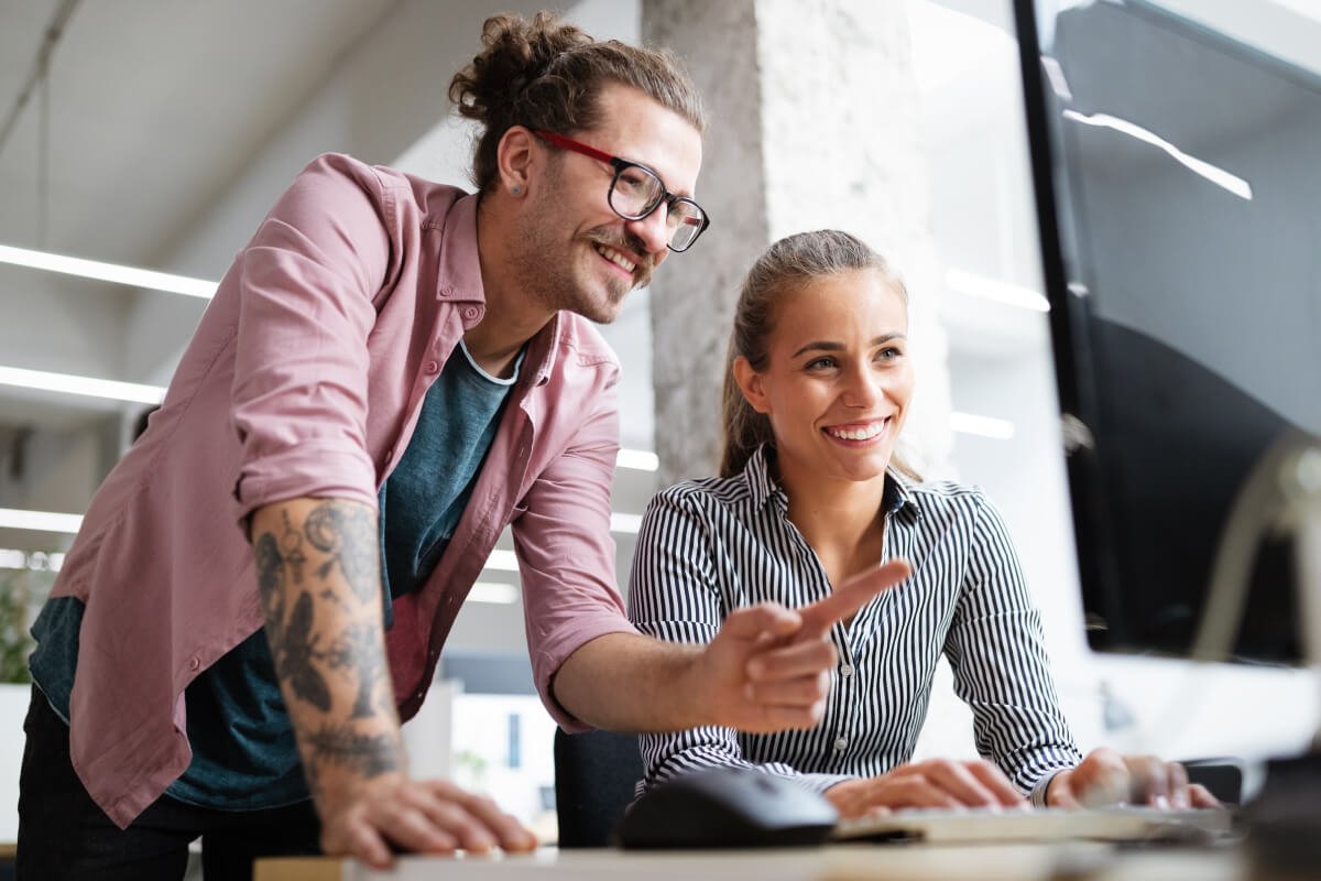 a man and woman looking at a computer screen