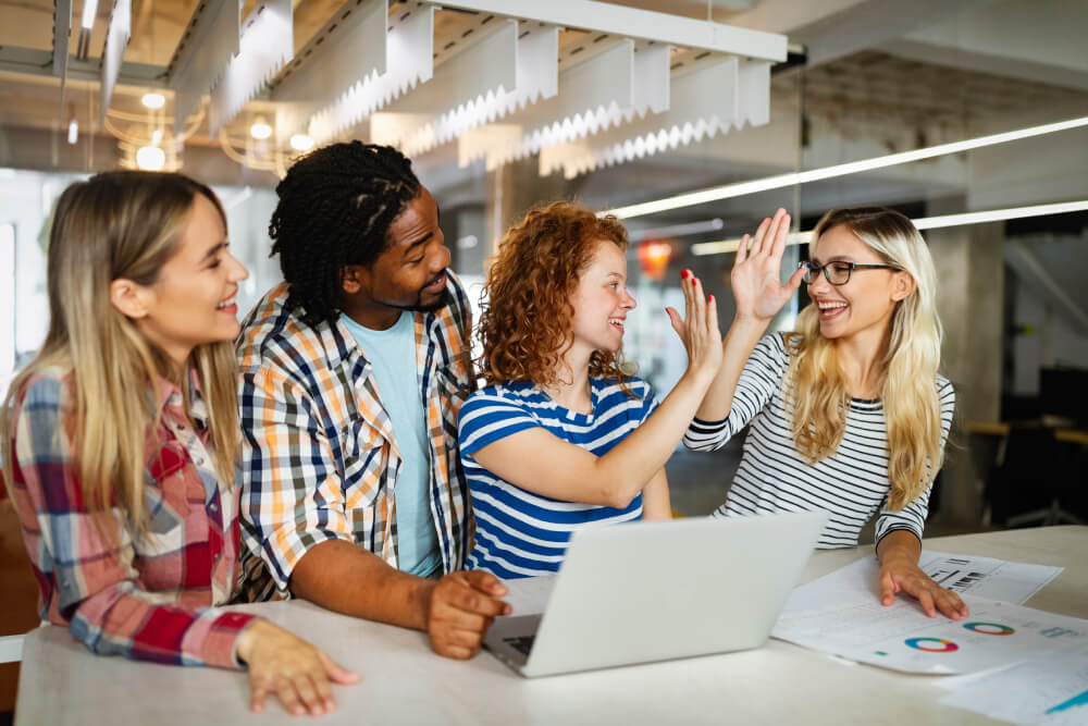 a group of people sitting at a table with a laptop
